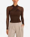 Woman wearing the Aurore brown draped mesh long sleeve top with beige trousers, front view