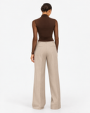 Back view of the Aurore brown draped mesh long sleeve top styled with beige trousers