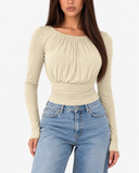 Esme apricot long sleeve top showing the gathered round neckline and ruched waist, styled with blue jeans
