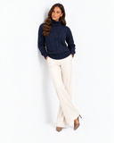 Harriet Dark Blue cable-knit roll-neck jumper, full-length front styling with crossed legs