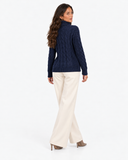 Harriet Dark Blue cable-knit roll-neck jumper, back view with cream wide-leg trousers