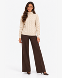 Harriet Apricot cable-knit roll-neck jumper, full-length front view with brown wide-leg trousers