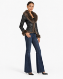 Three-quarter view of the Sabine black faux leather jacket styled with dark blue jeans