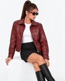 Seated front view of the Solange red faux leather biker jacket