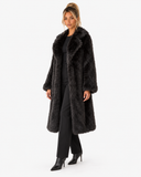 Three-quarter view of the Claudine black faux-fur coat, styled with black trousers.