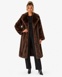 Full-length front view of the Claudine dark brown faux-fur coat, styled with black trousers.