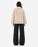 Back view of the ivory Eveline teddy-lined suede-look jacket on a model in black wide-leg trousers