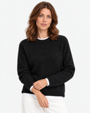 Close front view of the black knit sweater showing the neckline and cuffs.