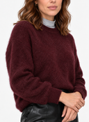 Close front view of the wine-red knit sweater showing the neckline and cuffs.
