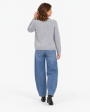 Back view of the grey long-sleeve knit sweater with blue jeans.