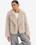 Noeline Beige Apricot faux-fur jacket in a front pose with one knee bent