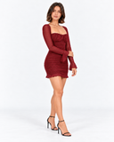 Three-quarter pose in the Orielle wine red mini dress with a ruched skirt and ruffled hem.