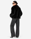 Rear three-quarter view of the Solenne black faux-fur jacket