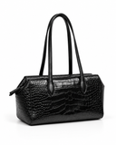 Angled view of a black crocodile-pattern tote bag showing its structured side and long handles.