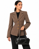 Woman carrying a black crocodile-pattern tote bag by the handles against a white background.