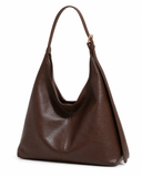 Brown faux leather shoulder bag shown at an angle with its single strap visible.