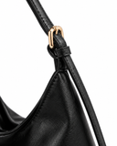 Close-up of the black faux leather shoulder bag strap, gold-tone buckle and stitched edge.
