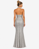 Back view of the Virelle silver sequin maxi dress showing the open back and full-length flared skirt.
