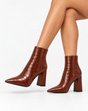 Violetta brown boots, worn side view with crossed legs.